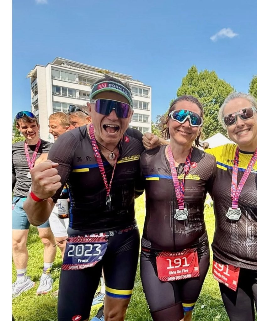 Frank Potreck, Jenni und Anika von der Staffel Girls on Fire nach dem Zieleinlauf beim Bonn Triathlon 2026