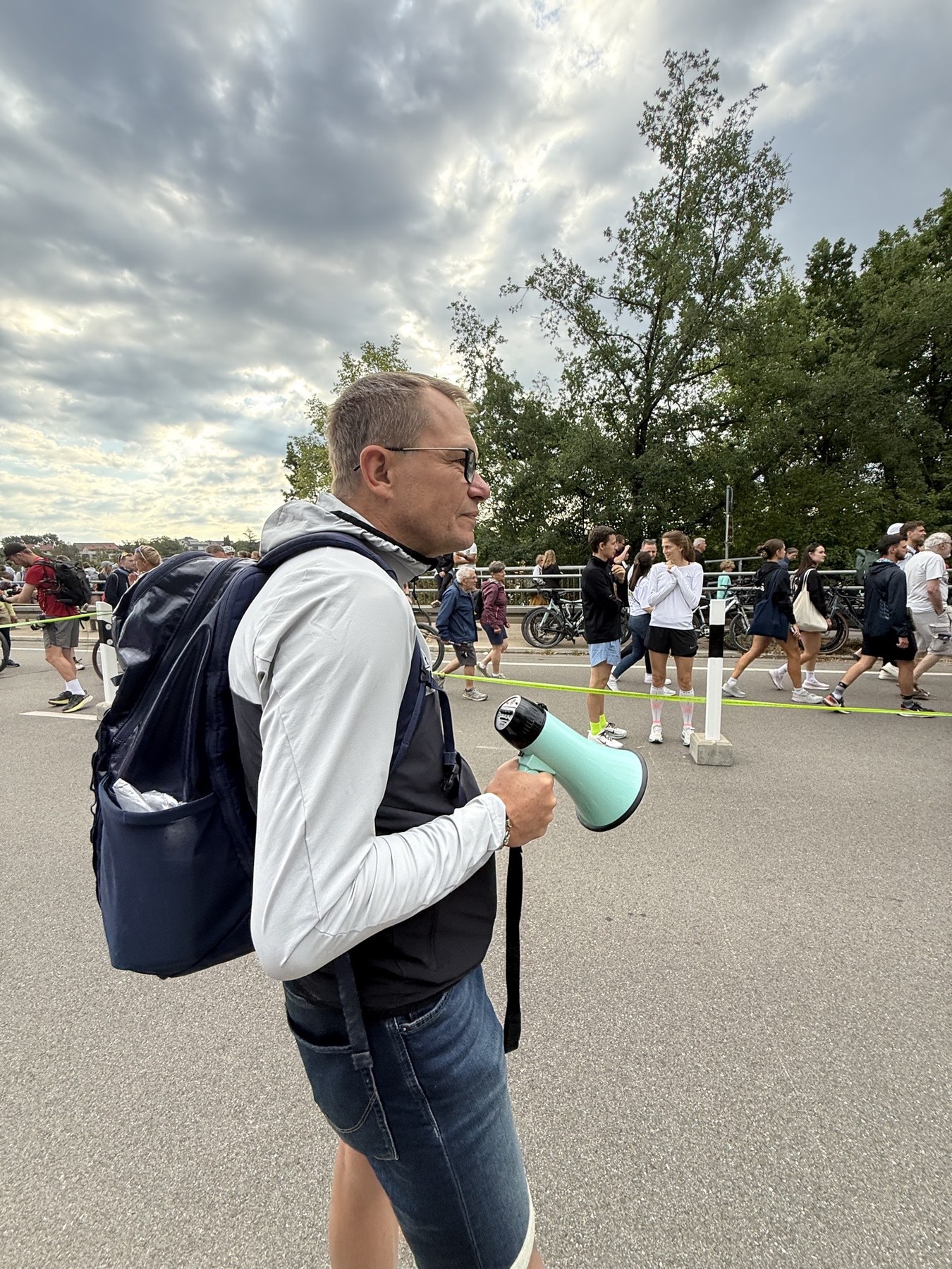 Helfer mit Megafon und Rucksack am Streckenrand der Challenge Roth 2026