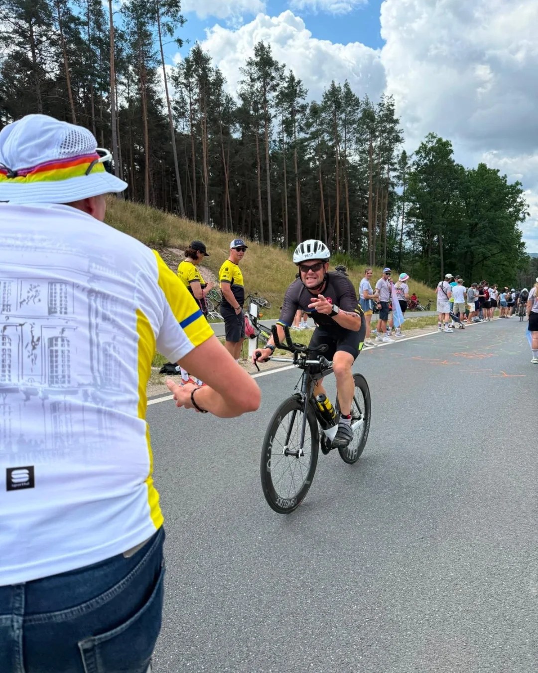 Uwe Hausmann vom PSV Brühl Triathlon Team mit Startnummer 1617 reicht auf der Radstrecke der Challenge Roth 2026 einem Zuschauer am Streckenrand die Hand