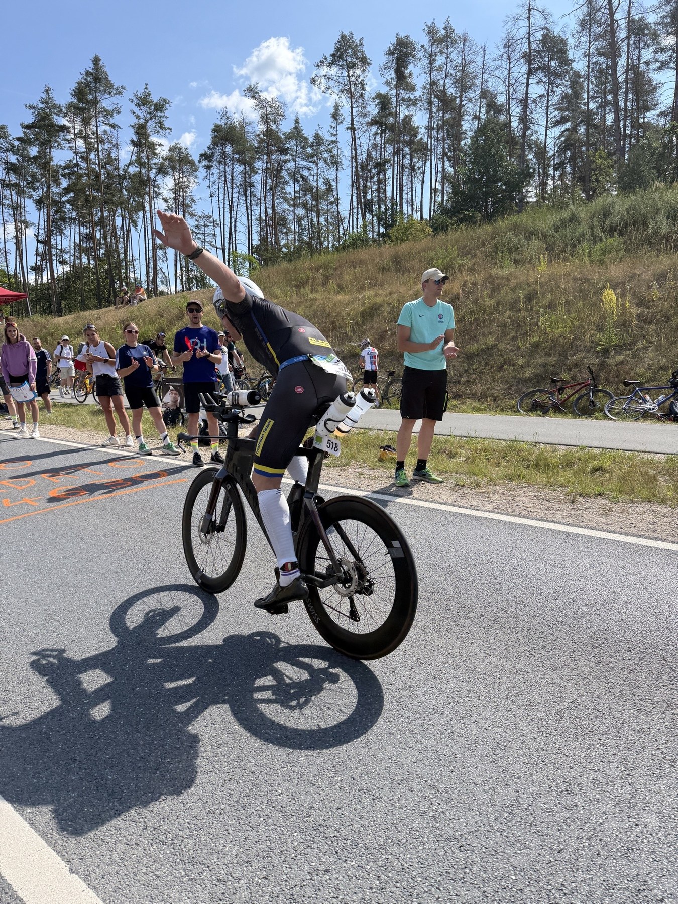 Simon Widera mit Startnummer 518 klatscht am Streckenrand mit Zuschauern ab – Challenge Roth 2026