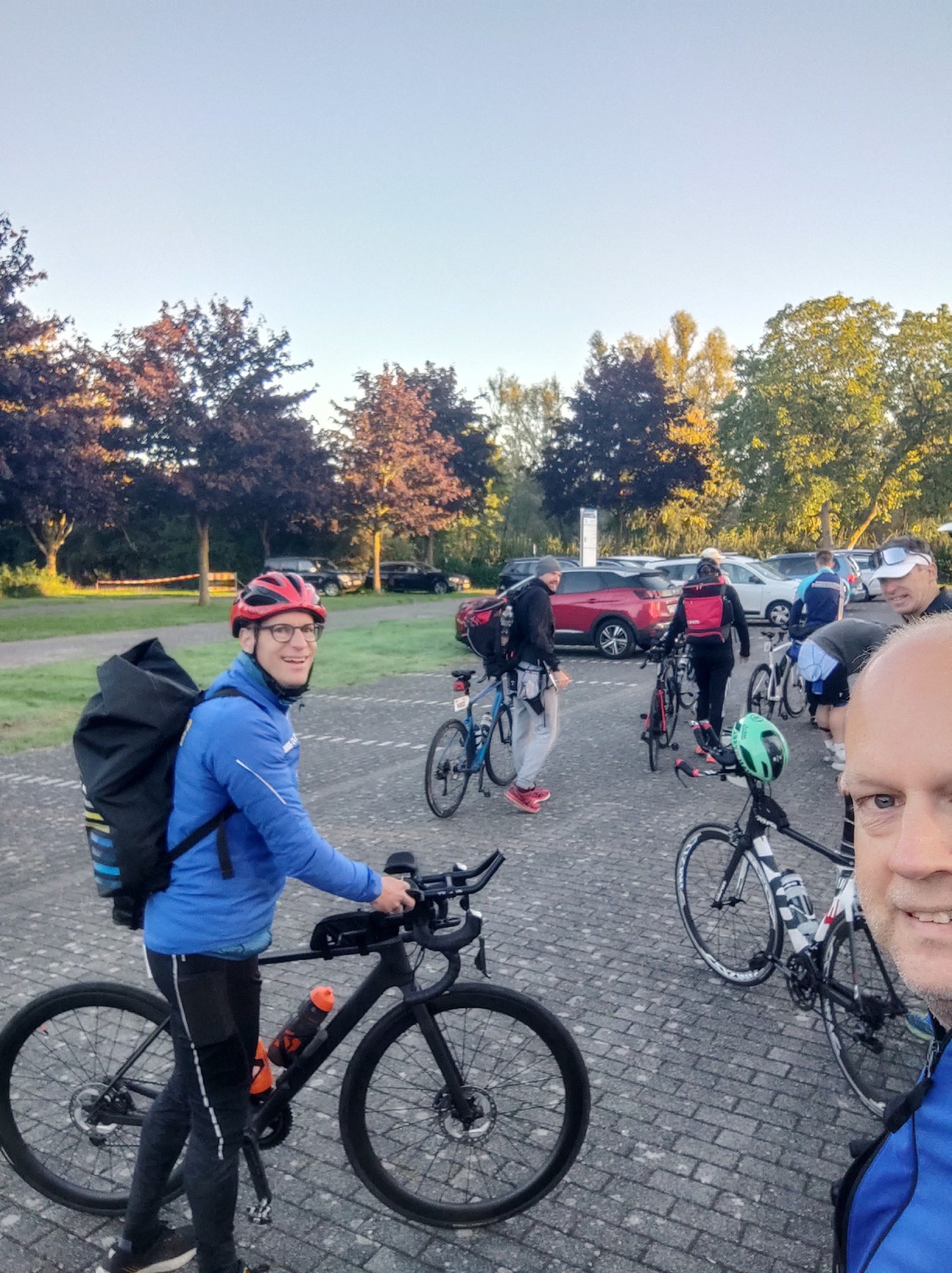 Athleten mit Rucksäcken und Rädern auf dem Parkplatz am Freizeitzentrum Xanten am Morgen des Nibelungen Triathlon