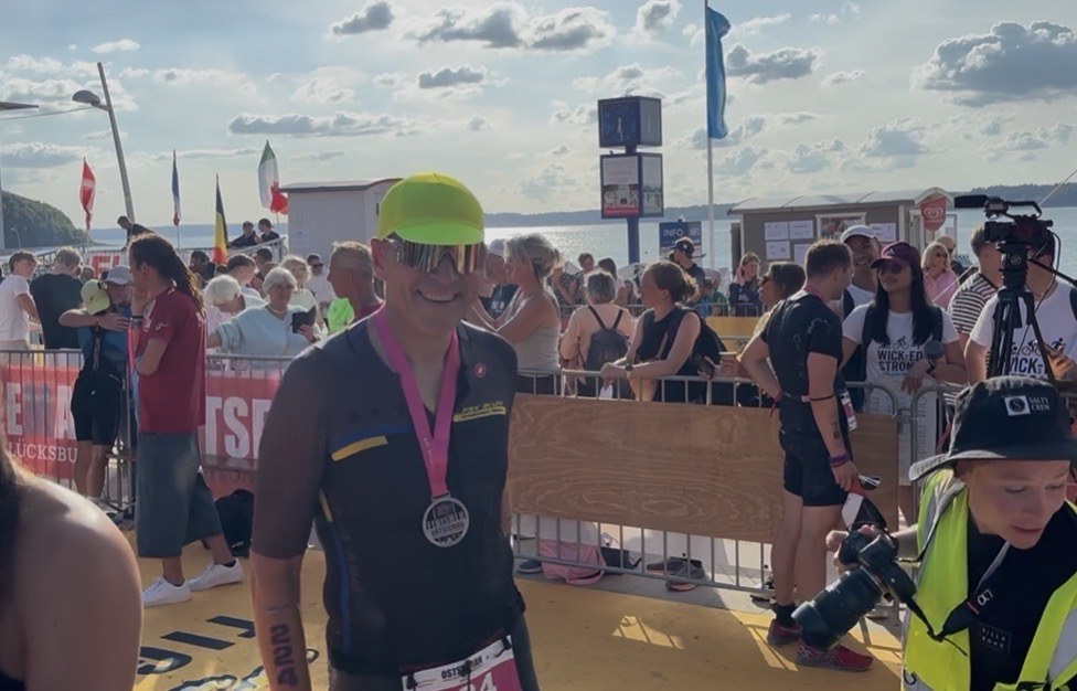 Bodo Sonntag vom PSV Brühl Triathlon Team mit der Finisher-Medaille um den Hals im Zielbereich des Ostseeman in Glücksburg